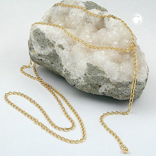 Collier long plaqué or porté sur une robe d'été