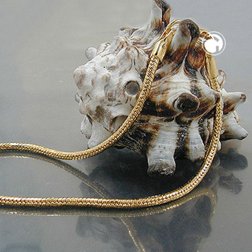 Gros plan sur bracelet doublé or chaîne serpent avec reflets lumineux